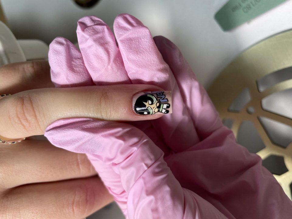 Buttercup din Powerpuff Girls pe o unghie, ținută într-o mănușă roz